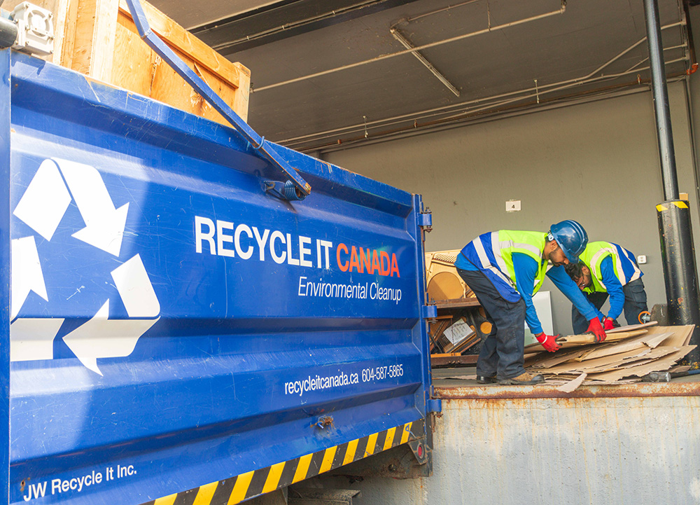 Recycle It canada crew doing a clean up next to a branded blue Recycle it Canada truck